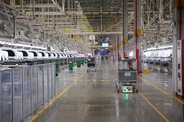 自動化牽引小車穿行在北汽株洲基地二工廠的總裝車間里。