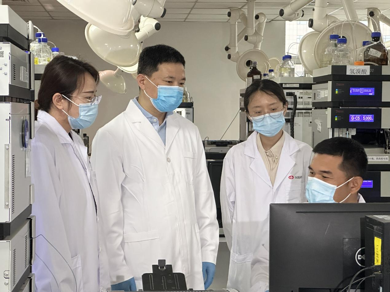 賈振華（左二）與科研人員在討論業(yè)務(wù)。 孫陽陽攝