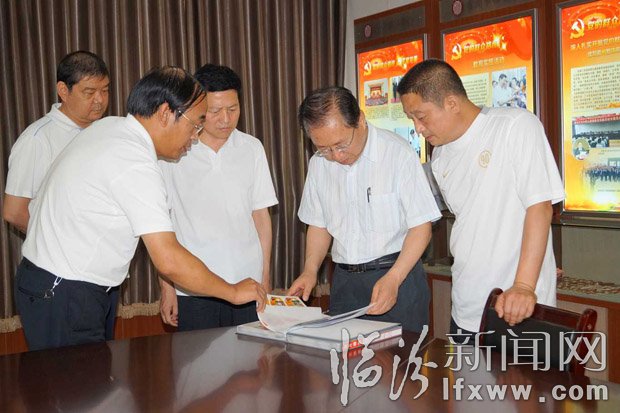 梁組長(zhǎng)一行在查閱照片檔案。
