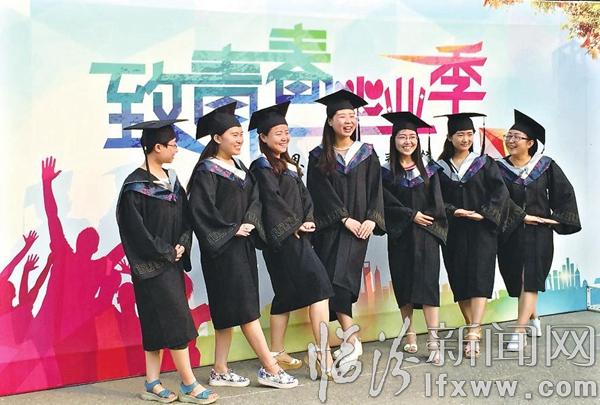 畢業(yè)生們?cè)凇爸虑啻海厴I(yè)季”主題墻前合影