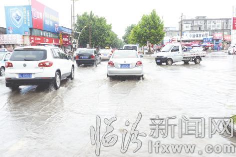 臨汾:車(chē)輛在水中“航行” 人們?cè)谟曛小翱春!? border=
